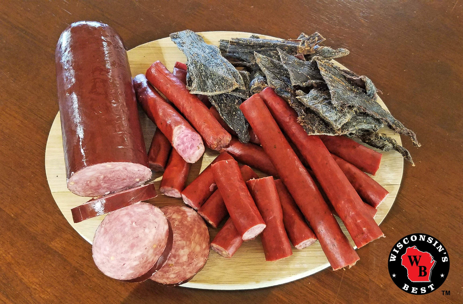 Meat snacks on a place, including: summer sausage, beef sticks and beef jerky